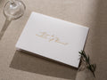 May include: A white card with gold lettering that reads 'Will you be my matron of honor?'