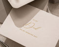 May include: A cream-colored greeting card with gold script that reads "TO MY Dad ON MY WEDDING DAY." The card is partially visible, with a matching envelope in the background. The card is simple and elegant.