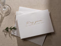 May include: White card with gold lettering that reads "To my groom on our wedding day".
