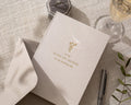 May include: A wedding card and envelope set in a neutral color, with the text "to my MAID OF HONOR on my wedding day" in gold lettering. A small floral design is above the text. A pen, a ring box, and a glass of champagne are also in the image.